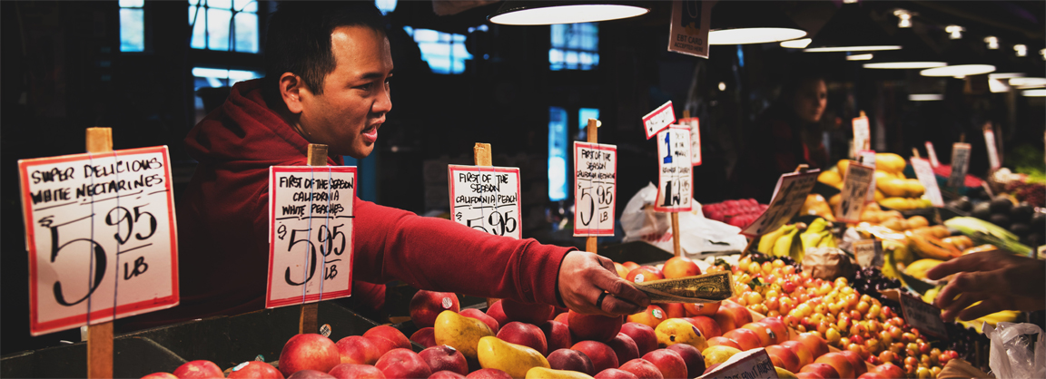 worker at fruitstand Photo by Tim Mossholder on Unsplash